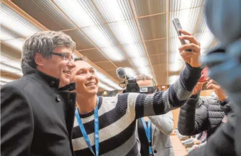  ??  ?? Puigdemont, fotografia­do en un «selfie» que realiza uno de los asistentes a su acto del domingo en GinebraAFP