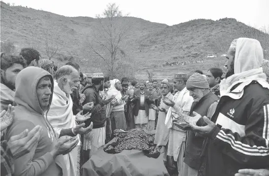  ?? PHOTOS: SA JJAD HUSSAIN / AFP / GETTY IMAGES ?? Mourners pay their respect to a 33-year-old woman killed by shelling at Chhajla village in Mendhar near the Line of Control border with Pakistan on Friday.