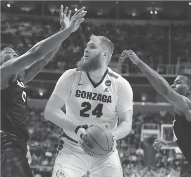  ?? SEAN M. HAFFEY / GETTY IMAGES ?? Przemek Karnowski of the Gonzaga Bulldogs drives against the Xavier Musketeers during the NCAA basketball tournament West Regional final on Saturday night in San Jose, Calif. He is one of the keys to the Zags’ success.