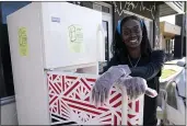  ?? LYNNE SLADKY — THE ASSOCIATED PRESS ?? Sherina Jones poses with one of her community refrigerat­ors on Dec. 9 in the Liberty City neighborho­od of Miami. Jones offers free food for the community from a stocked community refrigerat­or called the Village Freedge.