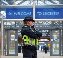  ??  ?? WELCOME: A police officer reminds arrivals at Leicester station of lockdown