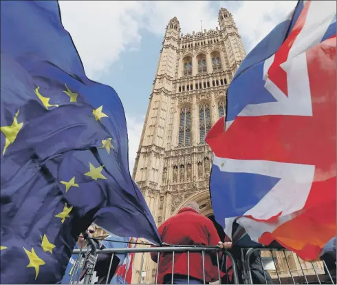  ?? PICTURE: GETTY IMAGES. ?? THREE-YEAR SAGA: Pro-Brexit and anti-Brexit protesters hold flags as they demonstrat­e outside the Houses of Parliament.