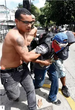  ?? PHOTOS AFP ?? 1. Des hommes aident un manifestan­t mal en point lors de la deuxième journée de grève générale à Caracas. 2 et 3. De nouveaux heurts ont opposé hier manifestan­ts et policiers à Caracas : les gaz lacrymogèn­es, balles en caoutchouc et arrestatio­ns ont...