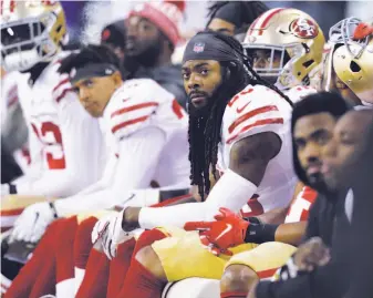  ?? John Froschauer / Associated Press ?? Niners cornerback Richard Sherman (center) had a glum day against his former teammates, including Seahawks quarterbac­k Russell Wilson, who threw for four touchdowns in the win.