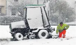  ?? Picture: Peter Jolly. ?? A grasscutte­r workman picks a bad day to get a puncture on his lawnmower as snow hits Aviemore.