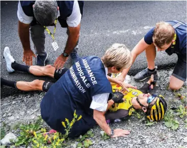  ??  ?? George gets checked over by medical staff after crashing on stage 18 to Valloire