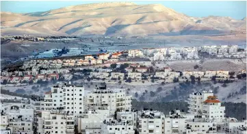  ??  ?? Picture shows a view of the Israeli settlement of Maale Adumim (centre) with the East Jerusalem Arab-inhabited Shuafat refugee camp seen in the foreground (below) and the Judaean desert in the background (top). — AFP photo