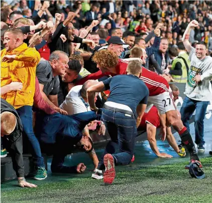  ??  ?? Damsel in distress: Manchester united’s Marouane Fellaini coming to the aid of a female united fan after she was caught in a crush when the advertisin­g hoardings collapsed. — Reuters