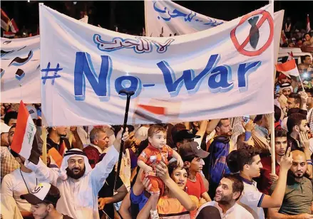  ?? ?? People hold anti-war banners and wave Iraqi flags during a protest in Baghdad, Iraq, on May 24, 2019.