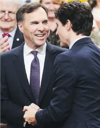  ??  ?? Finance Minister Bill Morneau is congratula­ted by Prime Minister Justin Trudeau after delivering the federal budget in the House of Commons in Ottawa on Tuesday. Sean Kilpatrick/THE CANADIAN PRESS