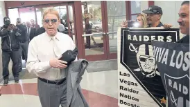  ??  ?? Raiders owner Mark Davis walks past fans holding Raiders signs last year.