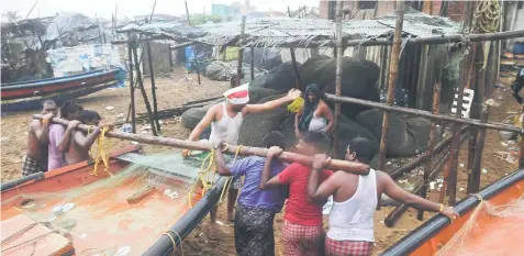  ??  ?? Indian fishermen pull a boat to higher ground on a beach in Puri in the eastern Indian state of Odisha as Cyclone Fani approached the Indian coastline. — AFP photos