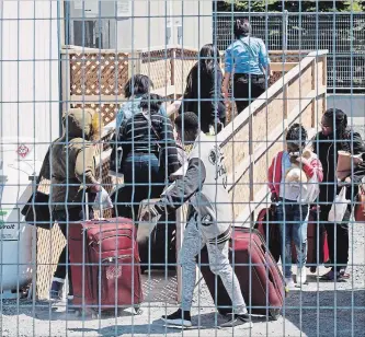  ?? RYAN REMIORZ THE CANADIAN PRESS ?? Asylum seekers arrive at the temporary housing facilities at the border crossing in St. Bernard-de-Lacolle, Quebec, in May.
