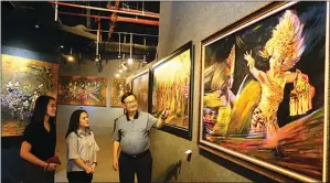  ??  ?? DITE SURENDRA/JAWA POS PUNYA ARTI KHUSUS: Rasmono Sudarjo menjelaska­n lukisannya kepada pengunjung. Lukisan-lukisan Rasmono dipamerkan di Shao Gallery, Grand City, mulai kemarin sampai 2 Desember.