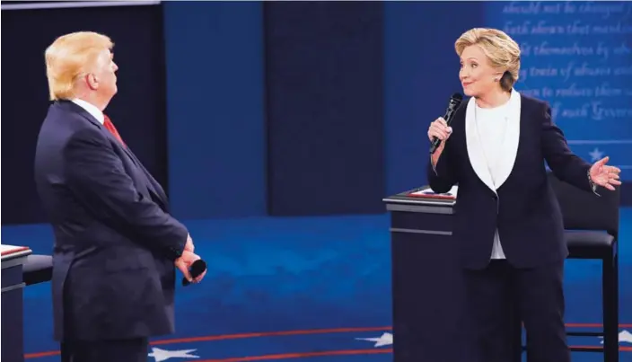  ?? AFP ?? El candidato presidenci­al republican­o, Donald Trump, prestaba atención a su contrincan­te demócrata, Hillary Clinton, durante el segundo debate entre ambos, anoche.