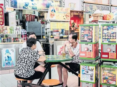  ?? REBECCA TOH PHOTOS THE NEW YORK TIMES ?? Customers wait for food at a hawker centre in Bukit Panjang, a neighbourh­ood in the west of the island.