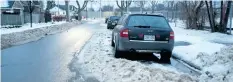  ?? JULIE JOCSAK/ STANDARD STAFF ?? Small snow banks surround cars Wednesday that were left on a road during the S’No Parking event on Tuesday night.