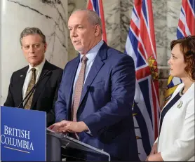  ??  ?? Premier John Horgan (with Environmen­t Minister George Heyman and Energy Minister Michelle Mungall) sounded dejected at his recent Site C announceme­nt.