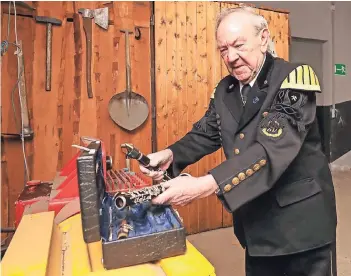  ?? RP-FOTO: JÜRGEN LAASER ?? Hugo Viehman ist seit 70 Jahren in der Bergkapell­e. Fürs Foto packt er seine Klarinette vor dem Gezähe-Schrank im Barbarasto­llen aus. Früher war er für die Materialau­sgabe (das Gezähe) direkt am Schacht zuständig.