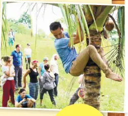  ??  ?? A Dutch delegate of MYX2016 tries climbing a coconut tree during a visit to the Cebu Technologi­cal University­Barili Campus.