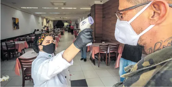  ?? TABA BENEDICTO / ESTADÃO ?? Controle. Restaurant­e do Ipiranga, na zona sul, cumpre o protocolo geral: luvas, máscaras também para clientes e termômetro na entrada