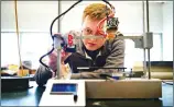  ??  ?? GREG LEHMAN / WALLA WALLA UNION-BULLETIN Walla Walla University student Austin Nordman preps the 3D printer he designed before a demonstrat­ion. Nordman has accepted a position with NASA.