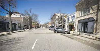  ?? Matthew Brown / Hearst Connecticu­t Media ?? A view looking up a largely empty Greenwich Avenue on March 27 in Greenwich. Brand Associate Gabriela Llanos poses outside Funky Monkey at 86 Greenwich Ave., in Greenwich on Tuesday. Funky Monkey offers curbside pickup for orders as a way to safely socially distance during the coronaviru­s pandemic.