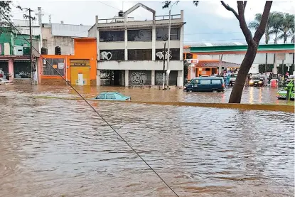  ??  ?? Autos quedaron bajo el agua en una de las avenidas de la capital veracruzan­a.