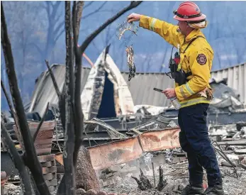  ?? Jim Wilson / New York Times ?? Firefighte­rs search a mobile home park Monday in the aftermath of the Camp Fire in Paradise, Calif.