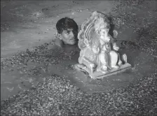  ??  ?? A Hindu devotee immerses the clay idol of elephant-headed Hindu god Lord Ganesha on the occasion of Ganesh Chaturthi festival.