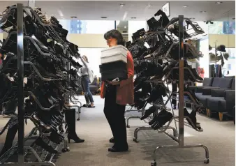  ??  ?? Sales associate Tina Kastoras searches for a shoe at Arthur Beren’s store at 222 Stockton St. in San Francisco, where it has been serving customers for nearly 30 years.