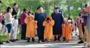  ?? BRIANA CONTRERAS — THE MORNING JOURNAL ?? Paige Nichols and Carlos Rosado walk with members of the kindergart­en graduating class during their Cap and Gown Walk May 23.