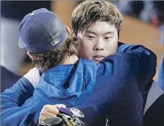  ?? Robert Gauthier Los Angeles Times ?? DODGERS PITCHER Hyun-Jin Ryu is embraced by teammate Clayton Kershaw after the starter pitched seven shutout innings against the Braves in Game 1 of the NLDS at Dodger Stadium.