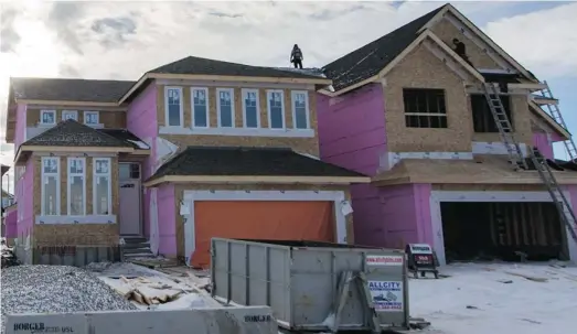  ?? Adrian Shellard/for the Calgary Herald ?? Single-family houses under constructi­on in Auburn Bay in southeast Calgary. Developers wonder if the city has enough serviced lots available for the future.