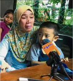  ??  ?? Emotional day: Gustiah with her son Muhd Bahrin reacting to the news of her husband Tayudin’s rescue.