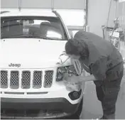  ?? MIKE HOUSEHOLDE­R/AP ?? In this image made from video, a worker washes a Jeep last month inside the service department of a LaFontaine auto dealership in Fenton Township, Mich.