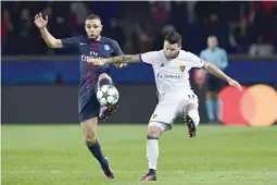  ?? — AFP ?? Basel’s Swiss midfielder Renato Steffen (right) challenges Paris Saint-Germain’s French defender Layvin Kurzawa during the UEFA Champions League group A match at the Parc des Princes Stadium in Paris.