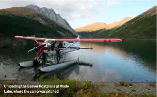  ?? ?? Unloading the Beaver floatplane at Wade Lake, where the camp was pitched