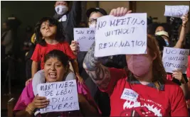  ?? RINGO H.W. CHIU — THE ASSOCIATED PRESS ?? Kenia Alcocer, carrying her son Genaro, protest before the cancellati­on of the City Council meeting in Los Angeles on Wednesday.