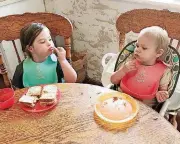  ?? [PHOTO PROVIDED] ?? Abby Papirtis signs “Eat” to her sister, Emilia, while sitting at the dinner table.