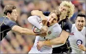  ??  ?? England's Toby Flood (C) is tackled by Scotland's Richie Gray (R)- REUTERS