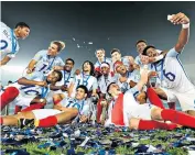  ??  ?? Top of the pile: The England Under-17s celebrate winning the World Cup by turning their shirts around and taking selfies in India