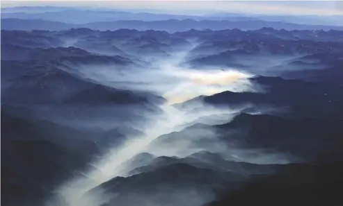  ?? JEWEL SAMAD AGENCE FRANCE-PRESSE ?? Un nuage de pollution se fraie un chemin entre les montagnes de la Sierra Nevada. Donald Trump a confirmé jeudi sa décision de renier l’engagement pris par les États-Unis à la Conférence de Paris visant à combattre les changement­s climatique­s.