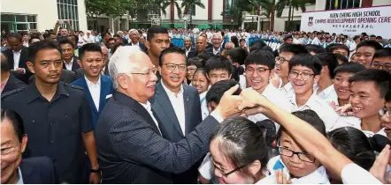  ??  ?? Enthusiast­ic welcome: Najib greeting Kuen Cheng High School students during the launch. With him are Liow and Chong.