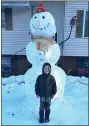  ??  ?? Skylar Thompson, 7, of Birdsboro, didn’t build this snowman, but loved it so much that he had to have his picture taken with it when he walked by it with his family.