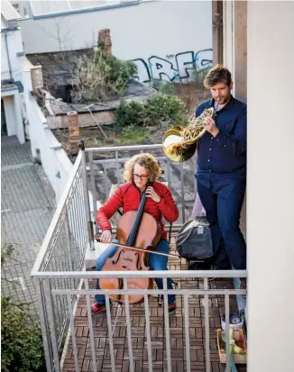  ??  ?? IN CONCERT
Karoline Strobl and Zoltan Macal perform Beethoven’s
“Ode to Joy” for their housebound neighbors in Dresden, Germany. The concert was duplicated by other musicians across the country.