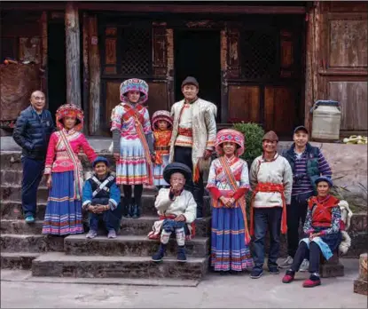  ??  ?? Photograph­er Chen Lin (left) takes a group photo with a family of four generation­s, the eldest member being 84 years old, from the Lisu ethnic group in Yunnan in 2018.