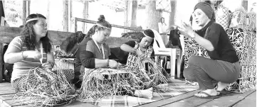  ??  ?? Weavers Bawe Adu, Zaria Ugil and Doris Lot demonstrat­e their weaving skills at the crafts bazaar.