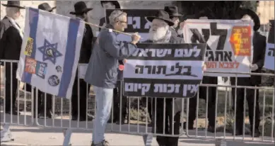  ?? -REUTERS ?? JERUSALEM
A protester, demanding equality in Israel's military service, confronts an ultra-Orthodox Jewish man demonstrat­ing in favour of military exemptions for religious seminary students in Jerusalem.