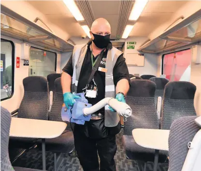  ??  ?? Deep cleaning on trains run by West Midlands Railway at New Street Station, Birmingham